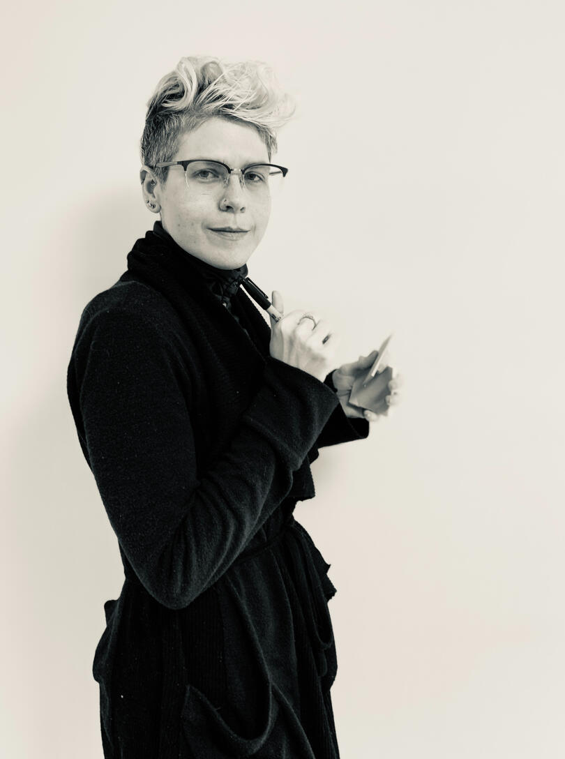 CJ, standing and holding post-its.